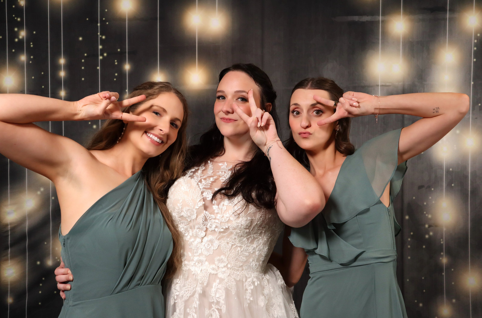 Bride and bridesmaids striking playful poses against a sparkling backdrop