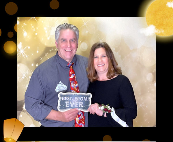 Couple holding a Best Prom Ever sign at a high school prom photo booth