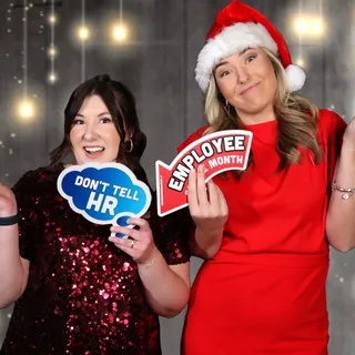 Coworkers holding office party signs at a corporate photo booth