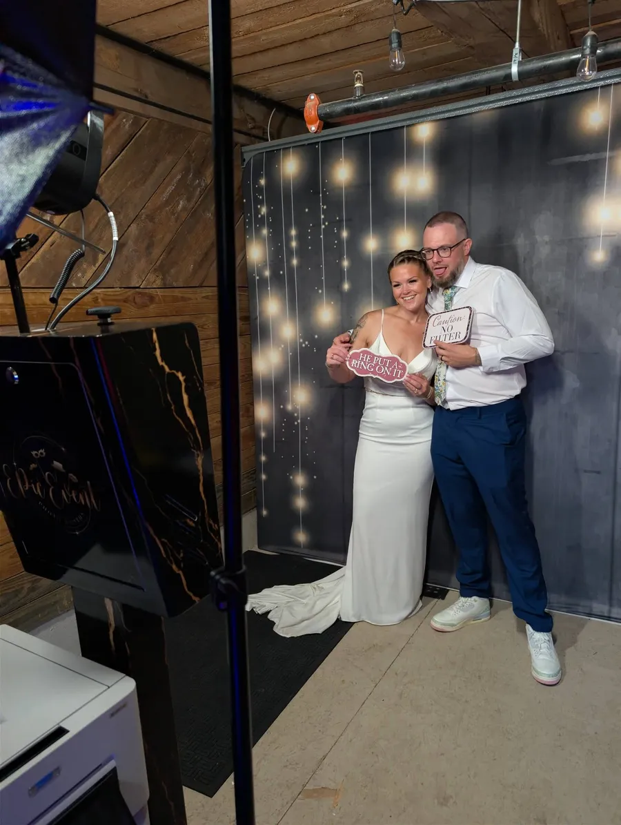 Bride and groom with He put a ring on it props at the Onyx booth